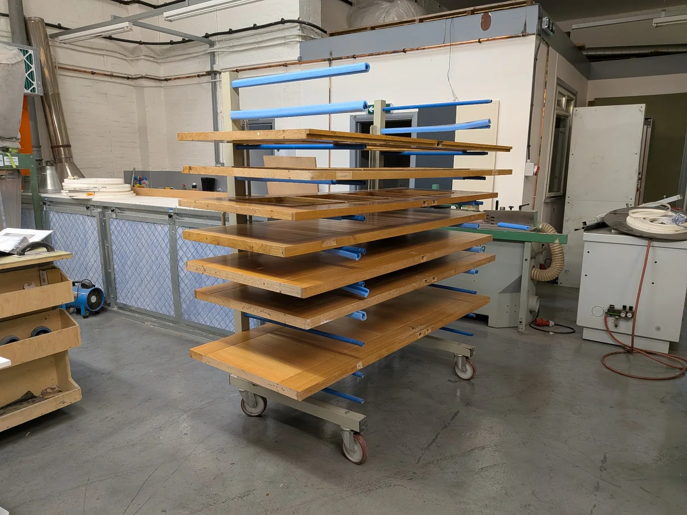 Doors on a finishing rack inside the Hassock Wood workshop